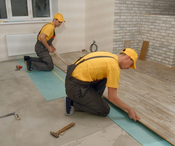 Men laying laminate flooring.
